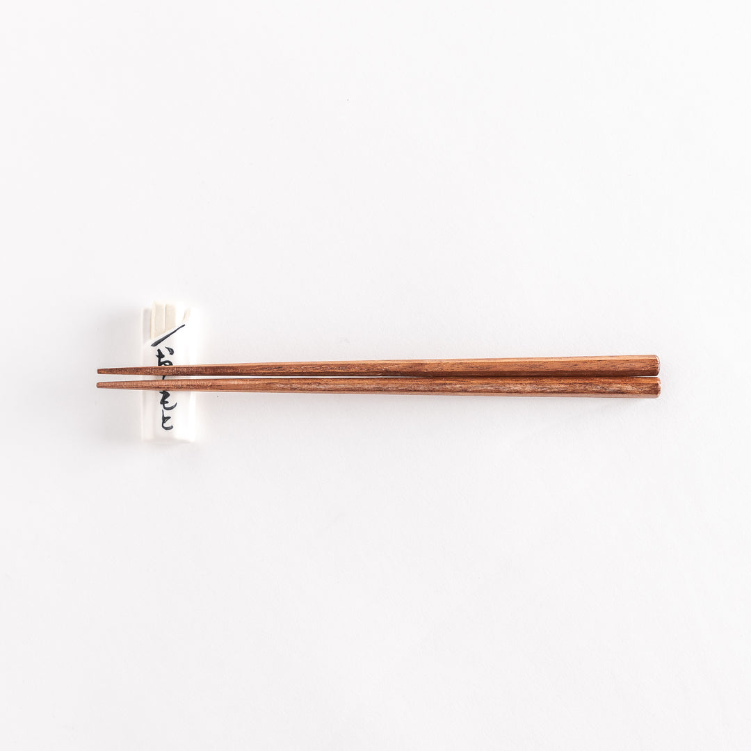 White to-go bag-shaped chopsticks rest with chopsticks positioned across its surface.