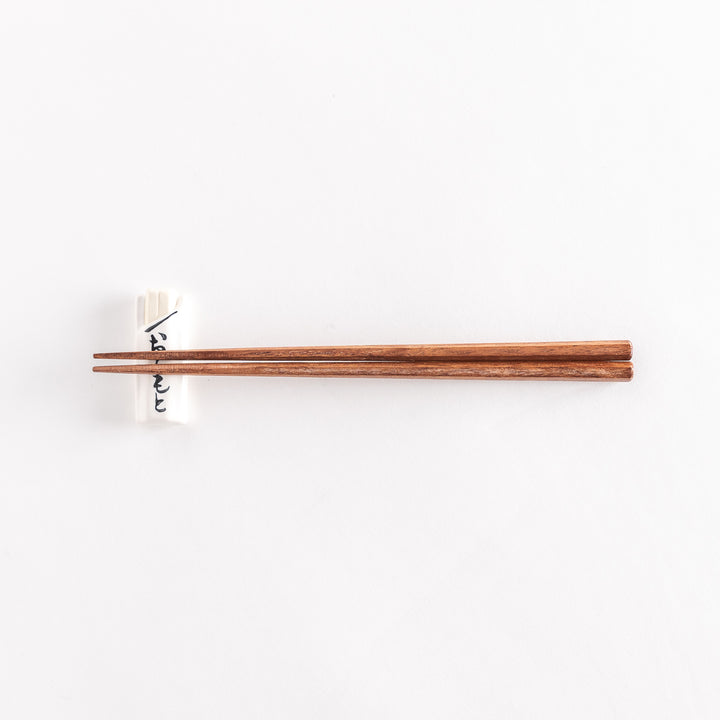 White to-go bag-shaped chopsticks rest with chopsticks positioned across its surface.