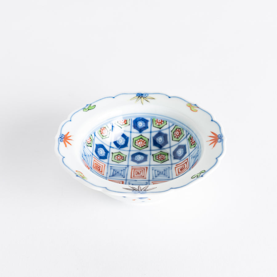 A porcelain bowl with colorful geometric patterns and floral motifs on the interior.