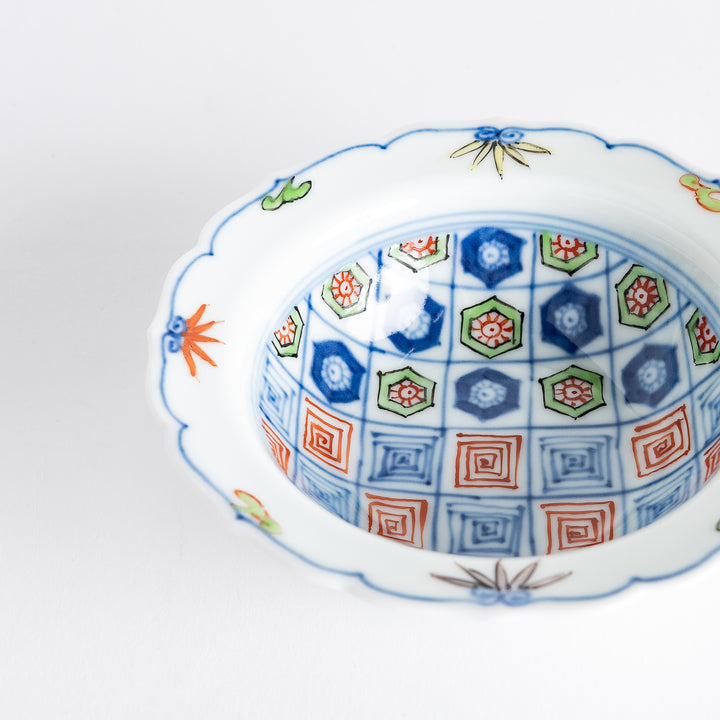 A porcelain bowl with colorful geometric patterns and floral motifs on the interior.