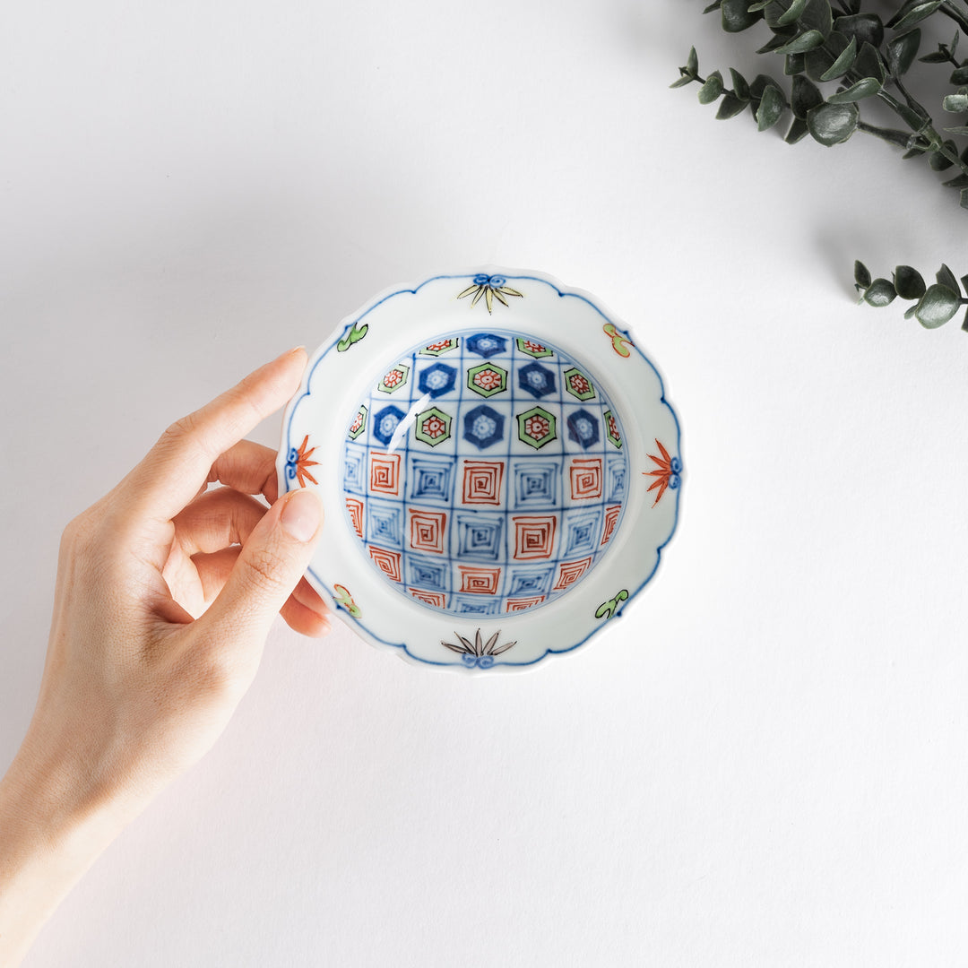 A porcelain bowl with colorful geometric patterns and floral motifs on the interior.