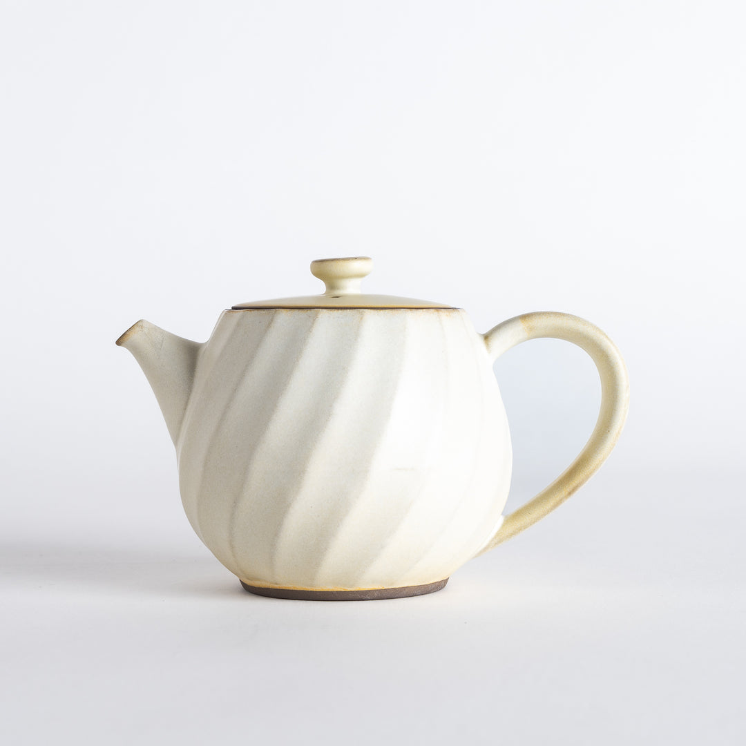 Teapot from a slight angle, emphasizing the refined craftsmanship and elegant contours of the handle and spout.