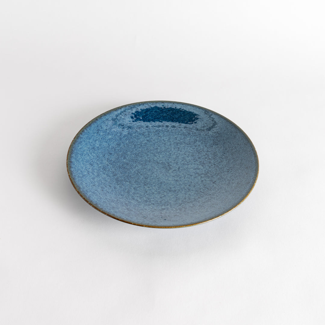 A round dinner plate with a deep blue gradient finish and a subtle textured surface.