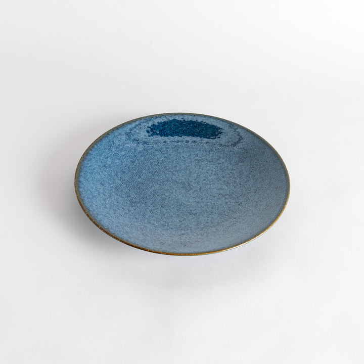 A round dinner plate with a deep blue gradient finish and a subtle textured surface.