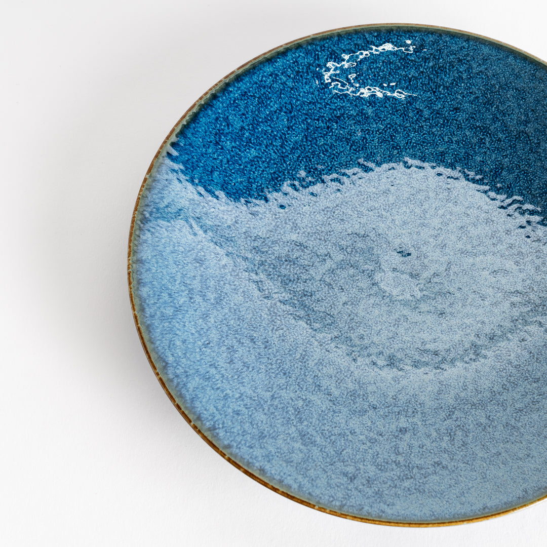 A round dinner plate with a deep blue gradient finish and a subtle textured surface.