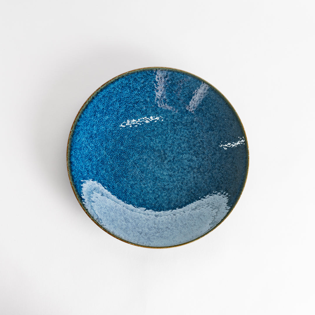 A round dinner plate with a deep blue gradient finish and a subtle textured surface.