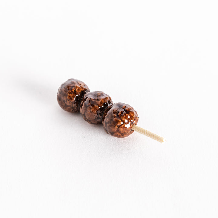 Slightly angled view of the tsukune chopsticks rest, showing its glossy and textured finish.