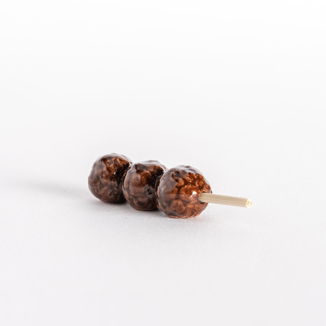 Side view of the skewer chopsticks rest, showing the meatball shape and wooden stick.