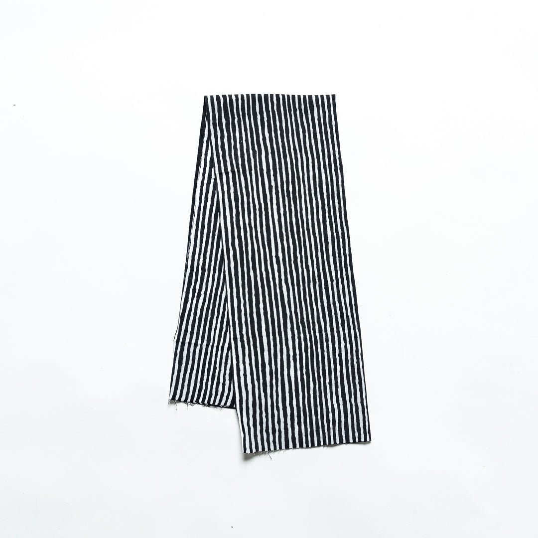 Black hand towel with vertical white stripes, folded neatly.