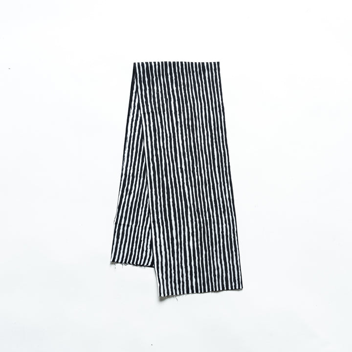 Black hand towel with vertical white stripes, folded neatly.