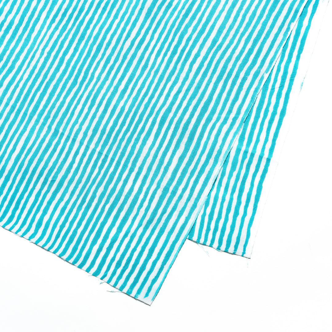 Close-up of the bright blue hand towel's vertical white stripe pattern.