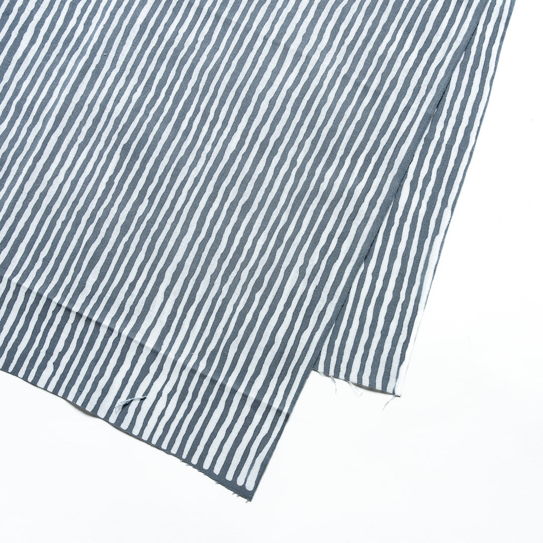 Close-up of the gray hand towel's vertical white stripe pattern.