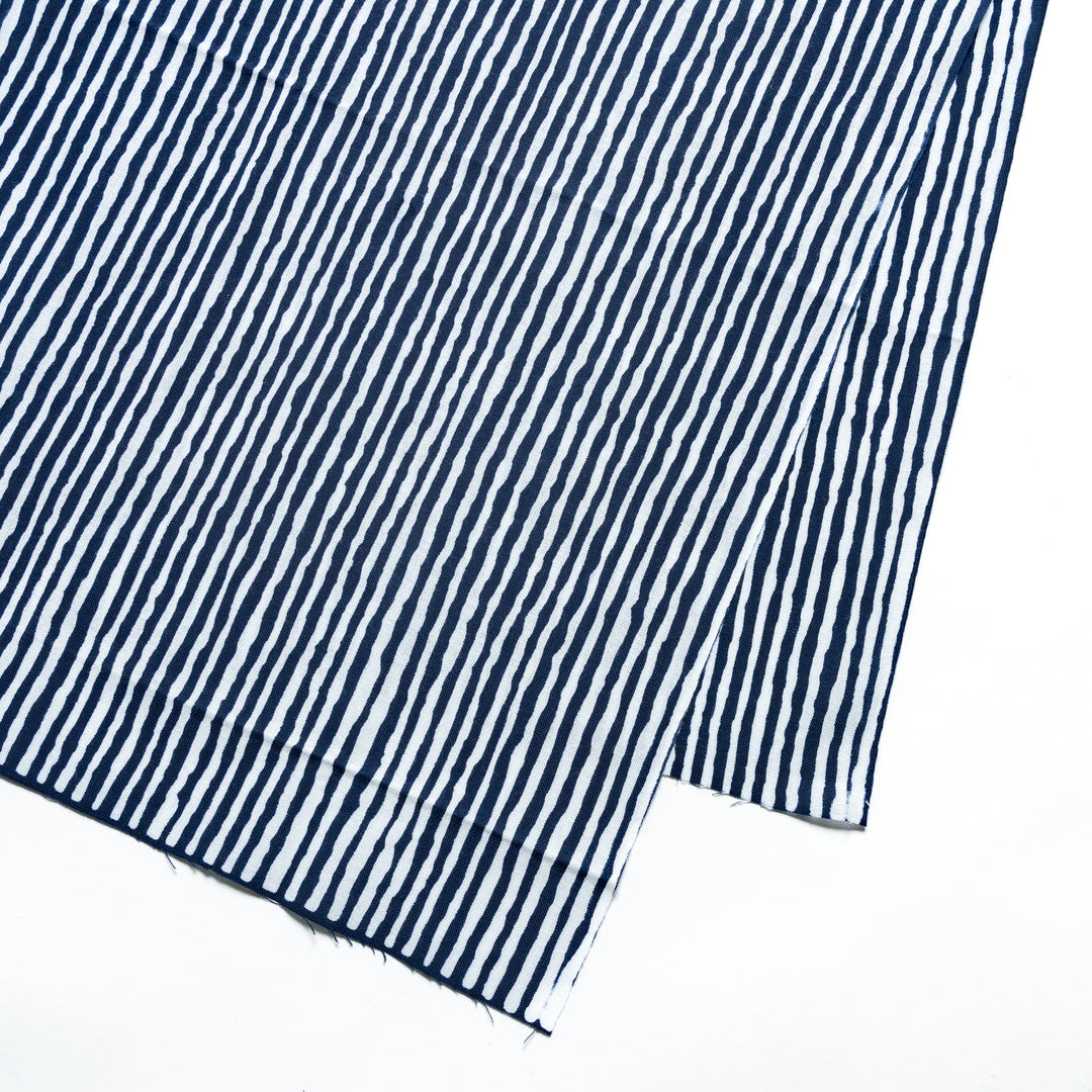 Close-up of the navy hand towel's vertical white stripe pattern.