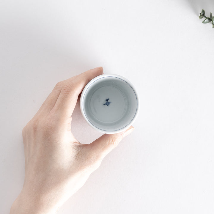 Hand-held view from above of the blue vertical bamboo line patterned bowl.