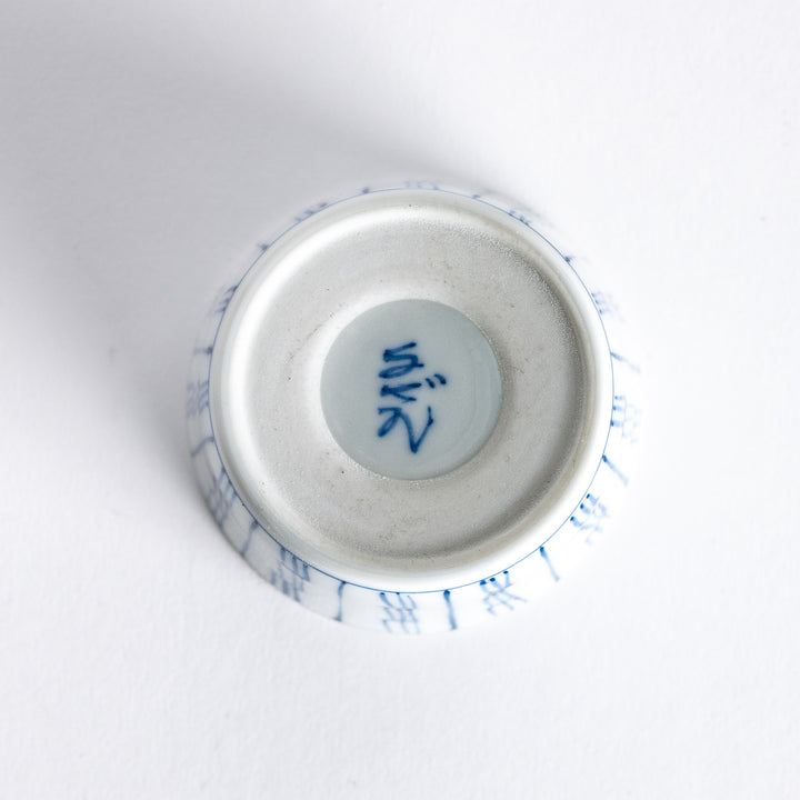 View of the underside of the blue vertical bamboo line patterned bowl, showing its plain white base.