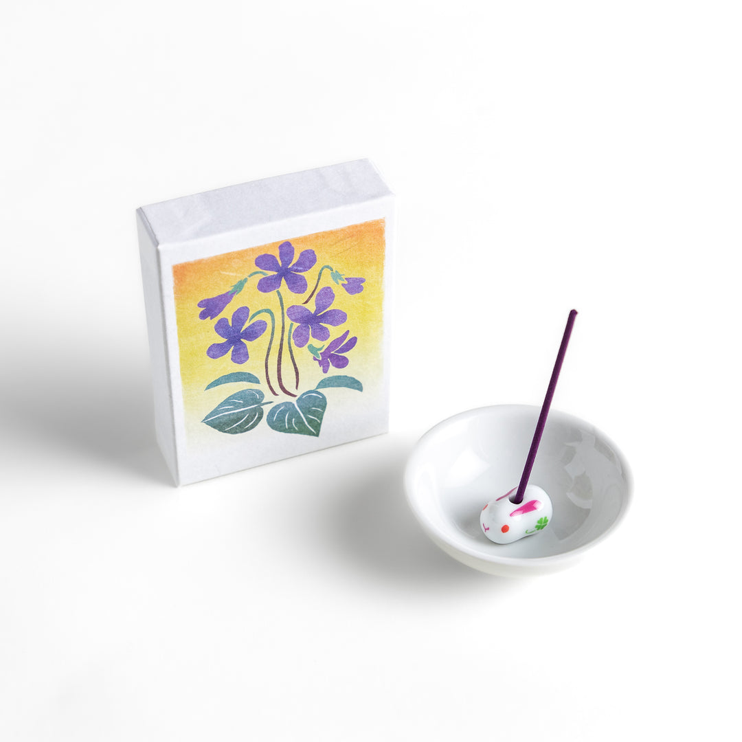 Incense featuring deep violet sticks in a box adorned with a delicate violet flower illustration, offering a floral and soothing fragrance for relaxation.