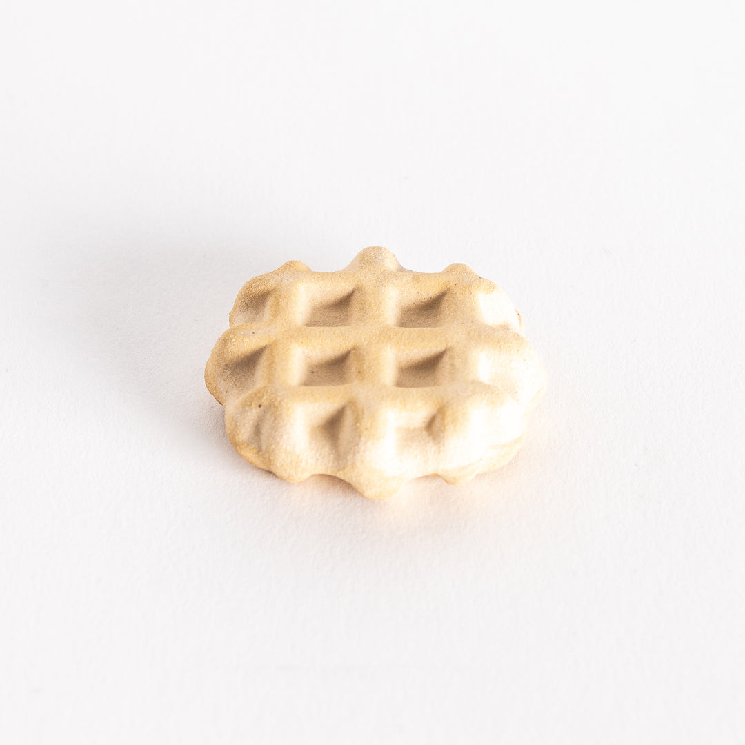 Slightly angled view of a ceramic waffle chopsticks rest, showing its detailed texture.