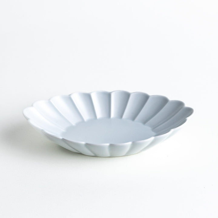 A white porcelain oval pasta bowl with a scalloped design.