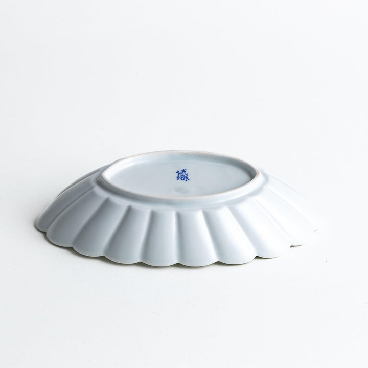 A white porcelain oval pasta bowl with a scalloped design.