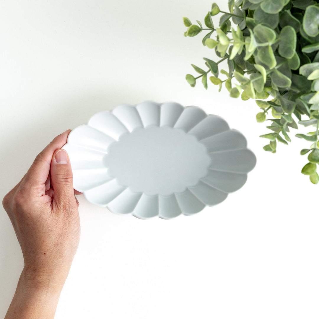 A white porcelain oval pasta bowl with a scalloped design.