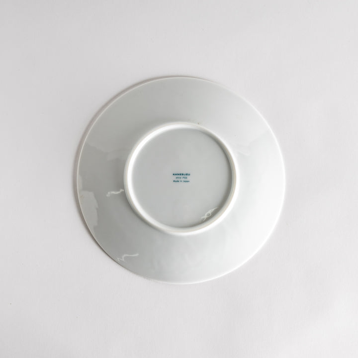 A white luncheon plate featuring a slightly irregular, organic texture and shape, providing a minimalist and natural look.