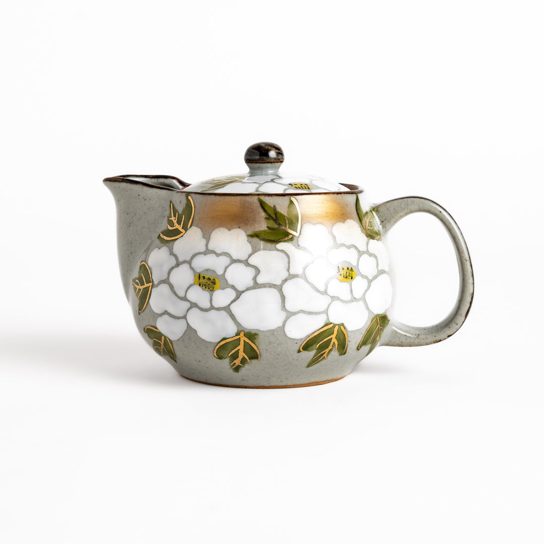 Elegant teapot adorned with white peony patterns, accented with gold and green leaves, perfect for sophisticated tea service.