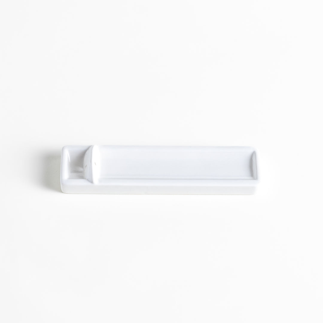 Incense Holder in a minimalist white ceramic design with a built-in slot for holding sticks, featuring a rectangular shape that neatly catches falling ash for a clean display.