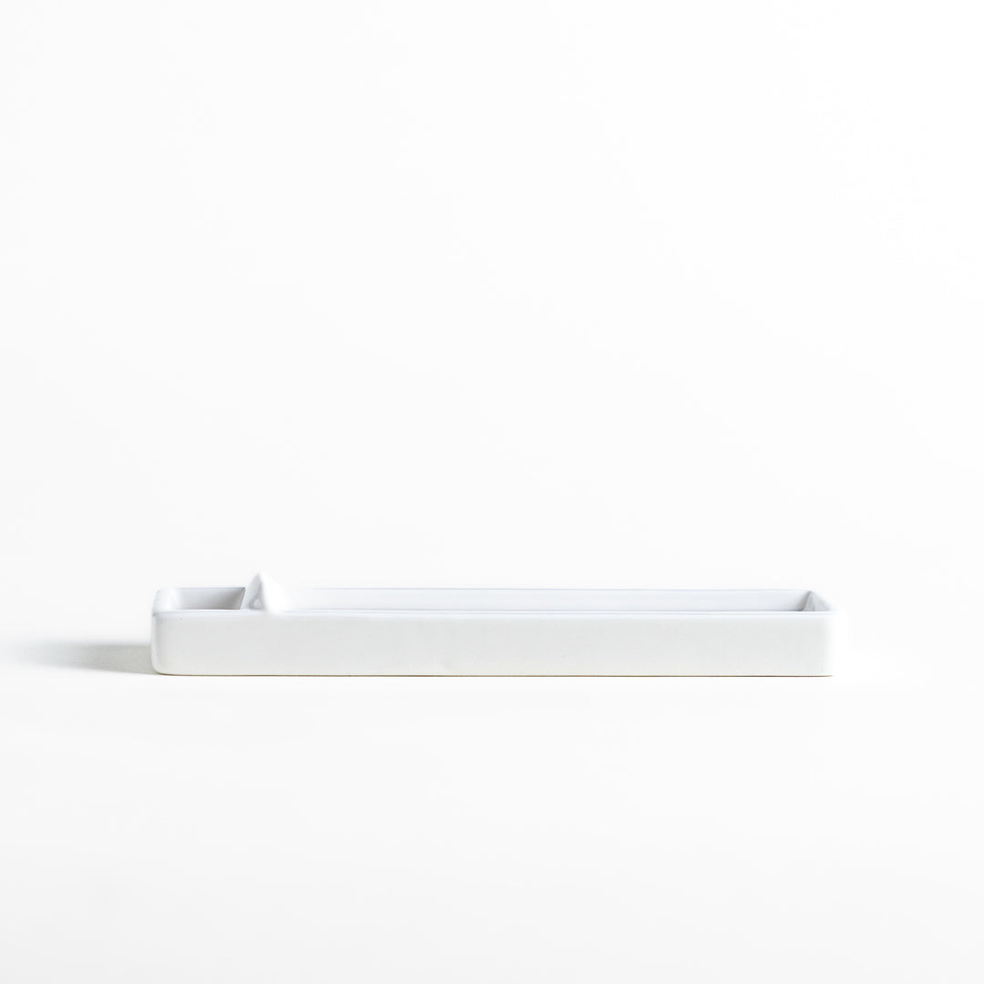 Incense Holder in a minimalist white ceramic design with a built-in slot for holding sticks, featuring a rectangular shape that neatly catches falling ash for a clean display.