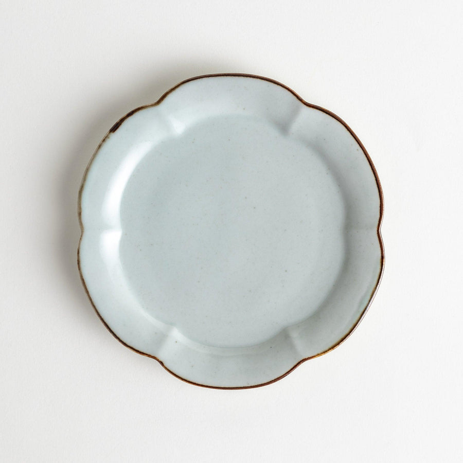 Earthy tones of olive, caramel, or off-white dessert plate, with a soft, rounded shape and subtle color variations.