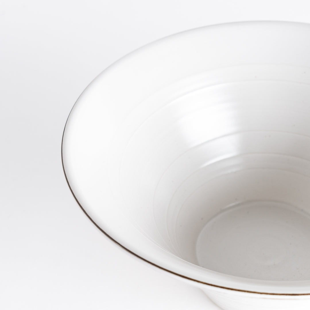 Close-up of the inside of the white ceramic bowl, displaying its spiral pattern and glossy finish.