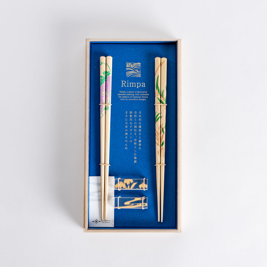 Elegant chopsticks featuring wisteria and bamboo designs, presented in a wooden box with a vibrant blue background. Ideal for thoughtful gifting.