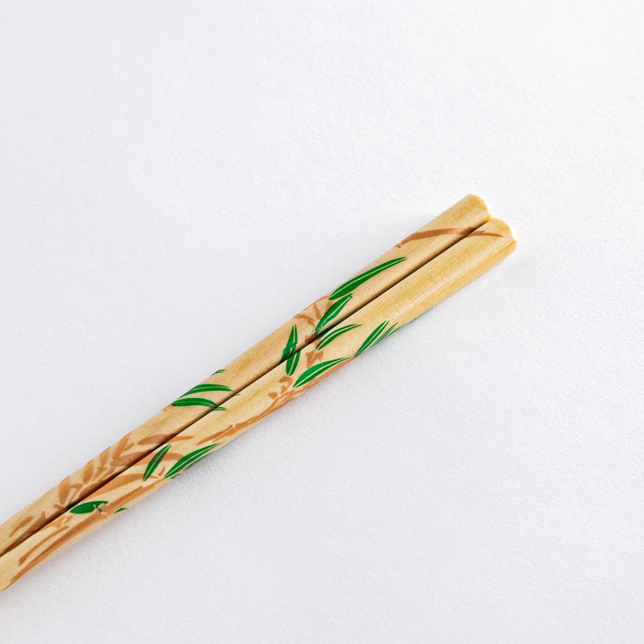 Detailed view of chopsticks with bamboo and wisteria design. The transparent stand complements the intricate patterns on the chopsticks.