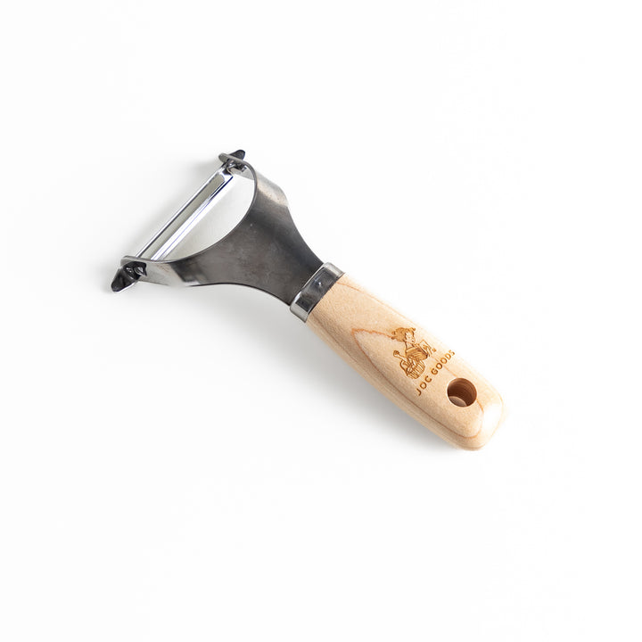 Wooden-handled julienne peeler with sharp stainless steel blade, featuring the JOC Goods logo, perfect kitchenware for vegetable strips.