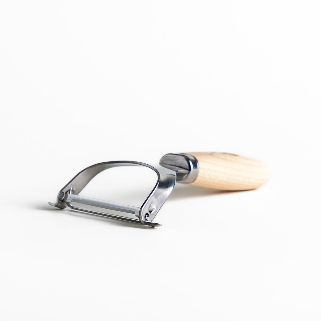 Wooden-handled julienne peeler with sharp stainless steel blade, featuring the JOC Goods logo, perfect kitchenware for vegetable strips.