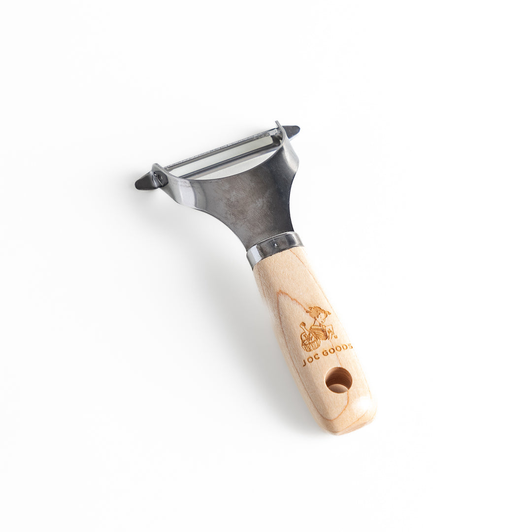 Japanese Wood Handle Peeler, a functional kitchenware with a stainless steel blade and ergonomic wooden handle, ideal for effortless vegetable peeling.