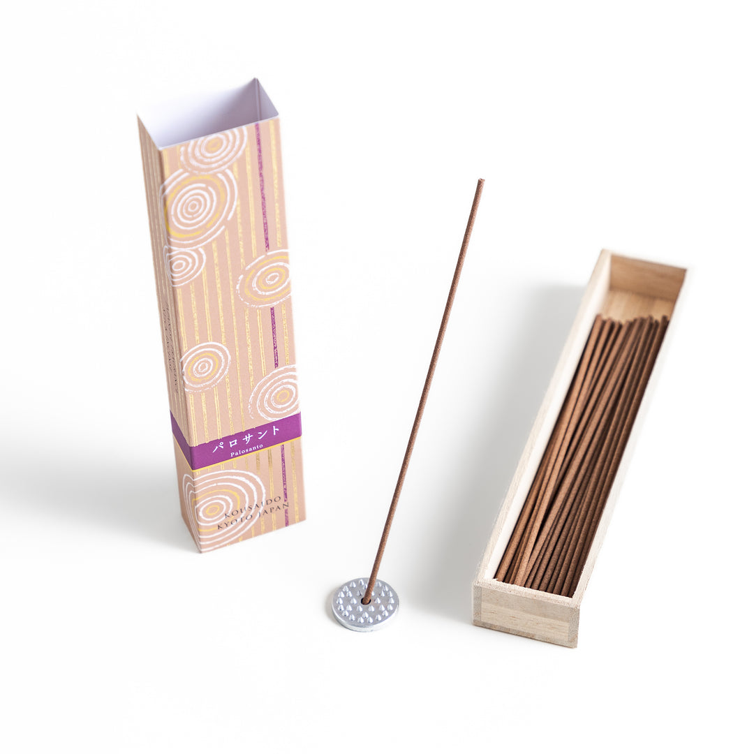 Woodland Palo Santo Incense in a light wooden box with warm brown sticks, elegantly packaged in a soft beige design featuring white circular patterns, evoking a calming and purifying Palo Santo aroma.