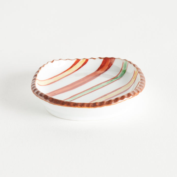 Side view of a sauce dish with colorful stripes and a textured rim, highlighting its unique shape and design.