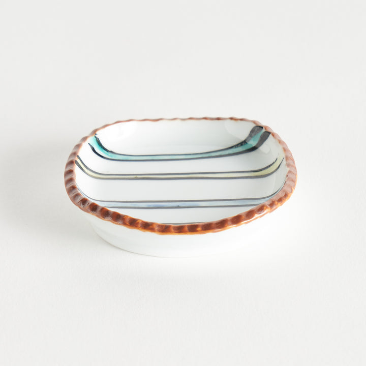 Angled view of rounded square plate featuring colorful horizontal stripes on a white background. 