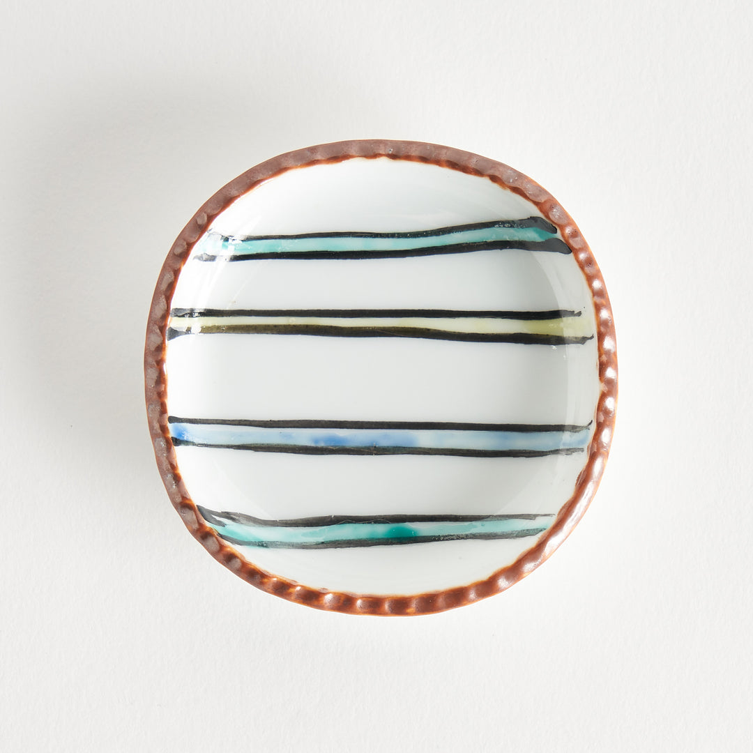 Beautiful round plate with brown edges and horizontal stripes in blue, green, black, and yellow on a white background.