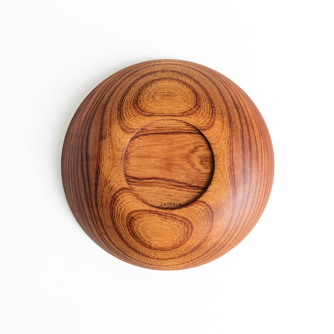 Bottom view of a Zelkova wood salad plate, highlighting the circular indentation and natural wood grain patterns.