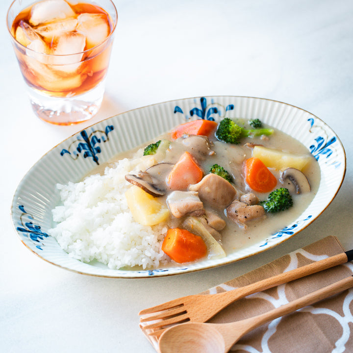 Creamy chicken stew served on a Floral Leaves Ridged Oval Dinner Plate.