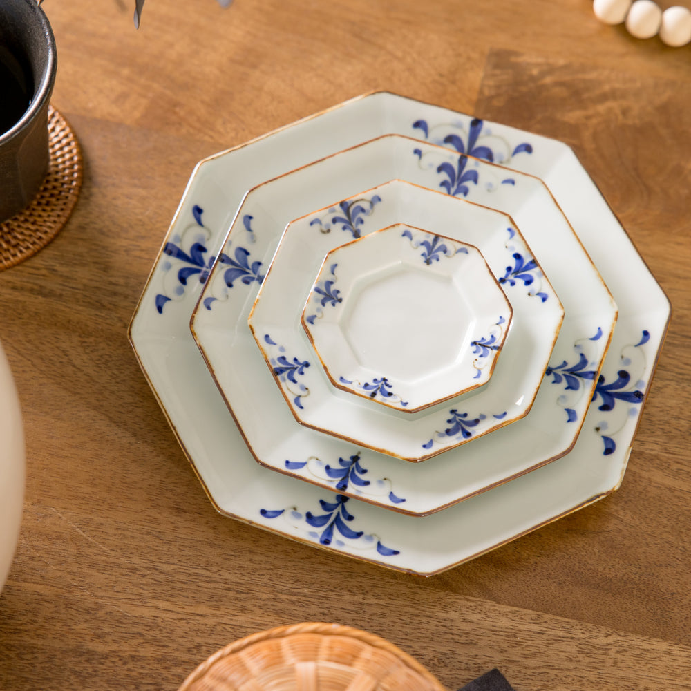 Octagonal white porcelain salad plate with a blue floral motif and brown accent trim.