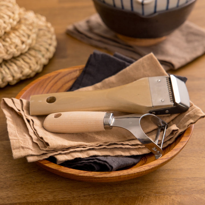 Set of peelers with wooden handles, designed for easy peeling and precise control.