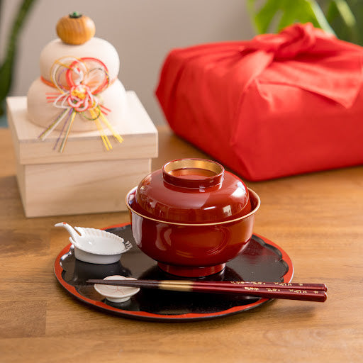 Vermilion miso soup bowl with lid on a black lacquer tray, accompanied by chopsticks and a crane-shaped condiment dish. Perfect for traditional Japanese dining.