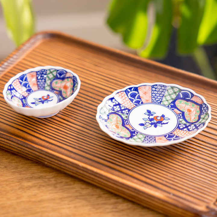 A floral salad plate with intricate gold detailing, showcasing a vibrant red flower at its center surrounded by intricate patterns in green, blue, and gold.