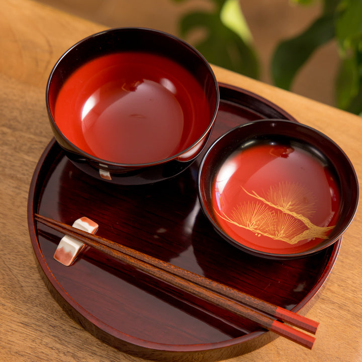 Elegant black lacquered bowl featuring a stunning gold inlay of pine trees. Perfect for enjoying miso soup or other dishes.