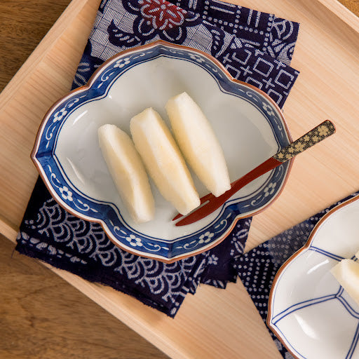 A delicate blue plum quince dessert plate elegantly holding sliced fruit, showcasing a refined touch for serving desserts or snacks.