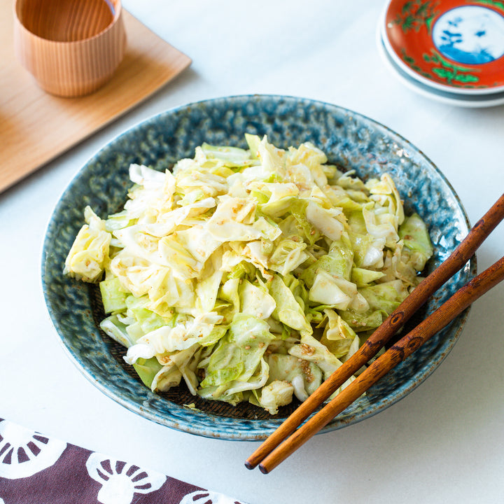 Indigo ceramic pasta bowl filled with a flavorful Japanese cabbage dish.