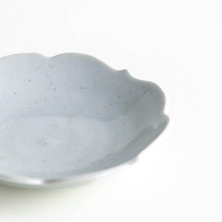 A small ceramic plate with a cloud-like shape, featuring a smooth white finish.