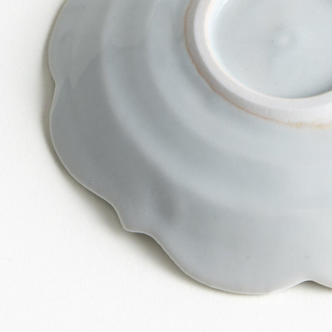 A small ceramic plate with a cloud-like shape, featuring a smooth white finish.